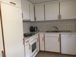 a kitchen with white cabinets and a sink at Appartement Fernsicht Triesenberg in Triesenberg