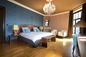 a bedroom with a large bed and a chandelier at Clementine in Kruishoutem