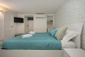 ein Schlafzimmer mit einem Bett und zwei Kissen darauf in der Unterkunft To Be Capri in Capri