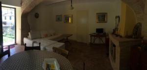 a living room with a white couch and a fireplace at Casavacanze Ciaspole E Uva in Fiastra