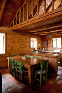 cocina con mesa de madera y sillas verdes en Sierra Paraiso Hotel en Mazamitla