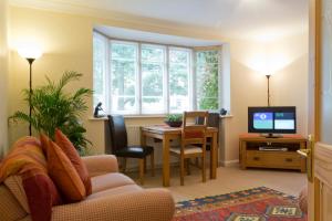 a living room with a couch and a table with a tv at Poplar House Serviced Apartments in York