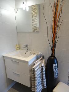 La salle de bains est pourvue d'un lavabo et d'un vase avec des serviettes. dans l'établissement rêverie, à Balaruc-les-Bains