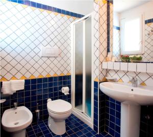 a blue tiled bathroom with a toilet and a sink at Residence Mediterraneo in Rimini +22 photos