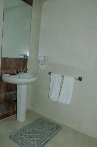 a bathroom with a sink and a mirror and towels at Sania Hotel in Sidi Bennour