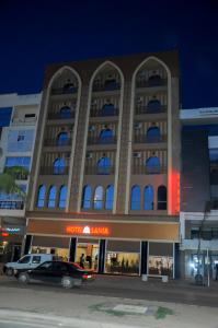 Sidi Bennour的住宿－Sania Hotel，前面有停车位的建筑