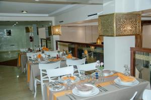ein Esszimmer mit weißen Tischen und weißen Stühlen in der Unterkunft Sania Hotel in Sidi Bennour