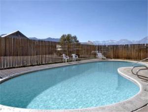 una piscina con 2 sillas y una valla en Super 8 by Wyndham Bishop en Bishop