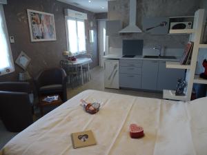 uma cozinha e sala de estar com uma mesa num quarto em rêverie em Balaruc-les-Bains