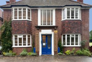 a white and blue house with a blue door at Poplar House Serviced Apartments in York