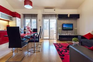 a dining room and living room with a red rug at Apartment Ina in Pula