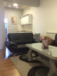 sala de estar con mesa y sofá en Apartman br.1, en Bijeljina