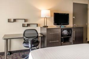 Habitación de hotel con cama, escritorio y TV. en Comfort Inn Largo-Washington DC East en Upper Marlboro