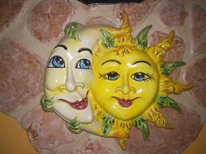 a mask of two smiling sun and moon at Attico Sole Luna in Taormina