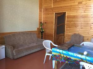 a living room with a couch and a table and chairs at Lahic Hostel in Lahıc