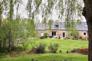 an old stone house with a large yard at Maison à la campagne in Louargat