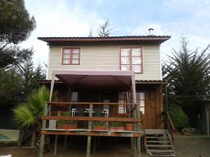 ein Haus auf Stelzen mit einer Veranda in der Unterkunft Cabañas La Querencia de Algarrobo in Algarrobo