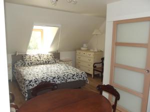 Schlafzimmer mit einem Bett, einem Fenster und einem Tisch in der Unterkunft Au Bonheur Frontalier in Steenvoorde