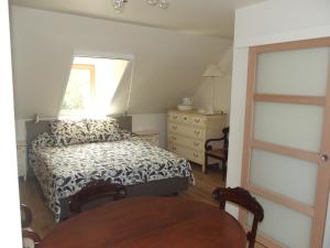 a bedroom with a bed and a window and a table at Au Bonheur Frontalier in Steenvoorde