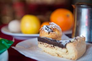 a piece of cake on a plate on a table with oranges at BeB le Frattocchie in Castel di Sangro