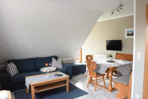 Una sala de estar con un sofá azul y una mesa. en Ferienhaus Eitel, en Spalt