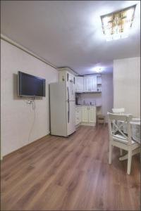 eine Küche mit einem Kühlschrank und einem Tisch im Zimmer in der Unterkunft Apartments Morskaya 31 in Sankt Petersburg
