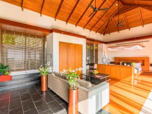 an open living room with a couch and a kitchen at Baan Paa Talee Estate - SHA Extra Plus in Kamala Beach