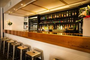 a bar with stools and bottles of alcohol at Bay Plaza Hotel in Wellington