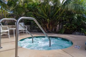 una bañera de hidromasaje con barandillas metálicas en una piscina en Wave Crest Resort en San Diego