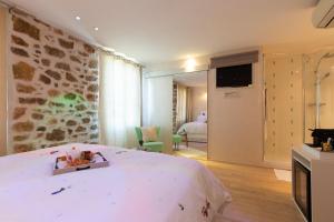 Habitación de hotel con cama y TV en la pared en Aby en Cannes
