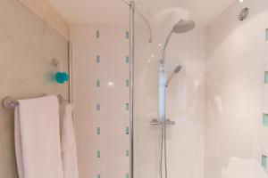 a shower with a glass door in a bathroom at Aby in Cannes