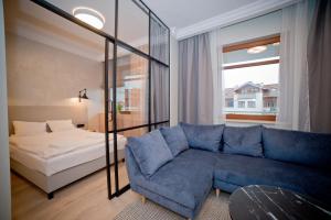 グダニスクにあるLucy Apartment Neptun Park - Hav Apartsのリビングルーム(青いソファ、ベッド付)