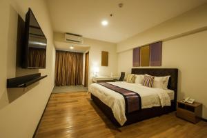 A bed or beds in a room at Aman Hills Hotel