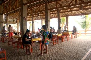 un grupo de personas sentadas en mesas en un restaurante en Chalemar Hotel Pousada, en Baía Formosa