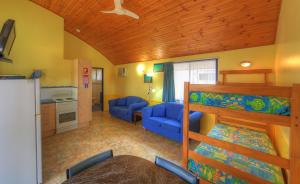 a living room with a bunk bed and a kitchen at Sunlover Lodge in Kinka