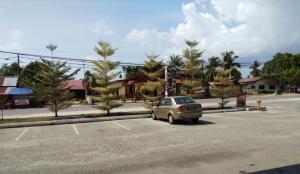 a car parked in a parking lot with palm trees at Salsa Resort Langkawi By Casa Loma in Pantai Cenang