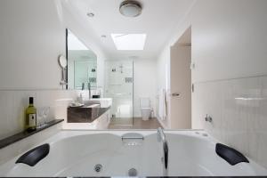 Baño blanco con bañera y lavamanos en Luna Blu - Luxury B&B en Rhyll