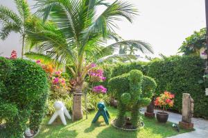 a garden with a palm tree and two people statues at Lamai Coconut Beach Resort in Lamai