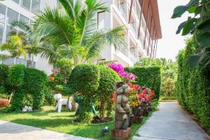 a garden with a statue in front of a building at Lamai Coconut Beach Resort in Lamai