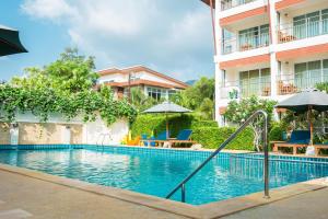 a swimming pool at a hotel with chairs and umbrellas at Lamai Coconut Beach Resort in Lamai