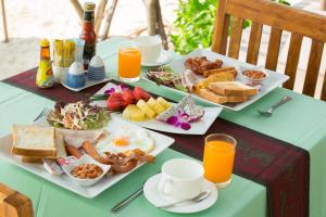 a table topped with plates of breakfast foods and orange juice at Lamai Coconut Beach Resort in Lamai