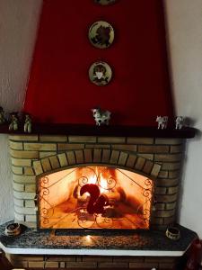a brick fireplace with a person engulfed in flames at Refúgio de Montanha em Monte Verde para Famílias e Amigos com 4 Suítes in Monte Verde