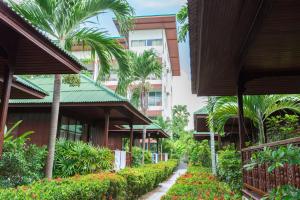 a walkway through a building with palm trees and flowers at Lamai Coconut Beach Resort in Lamai
