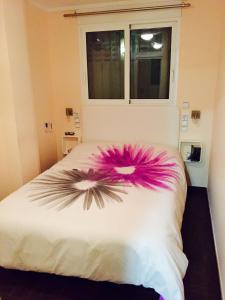 a bedroom with a bed with a pink flower on it at Apartamento de diseño en la mejor zona Playa Gandia in Gandía