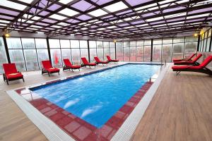 een groot zwembad met rode stoelen in een gebouw bij Amazing Hotel Sapa in Sa Pa