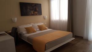 una camera da letto con un grande letto con cuscini arancioni di Casa Mafalda a Chioggia