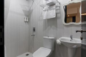 Un baño blanco con inodoro y lavabo. en M Home, en Yakarta