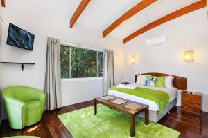 Un dormitorio con una cama y una silla verde. en Maleny Terrace Cottages, en Maleny 33 fotos más