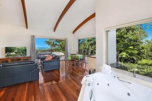 a large living room with a tub and a table and chairs at Maleny Terrace Cottages in Maleny