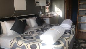 Un dormitorio con una cama grande con almohadas. en A Stone's Throw Accommodation, en Grahamstown